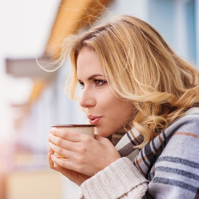 Beautiful woman relaxing at home with cup of  coffee